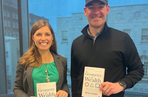 Katie Brown and Dennis Morton holding Shaping Wealth book